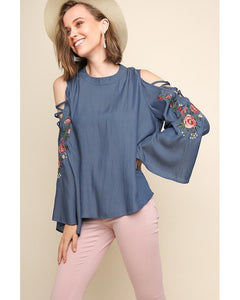 A blouse with floral embroidered bell sleeves.